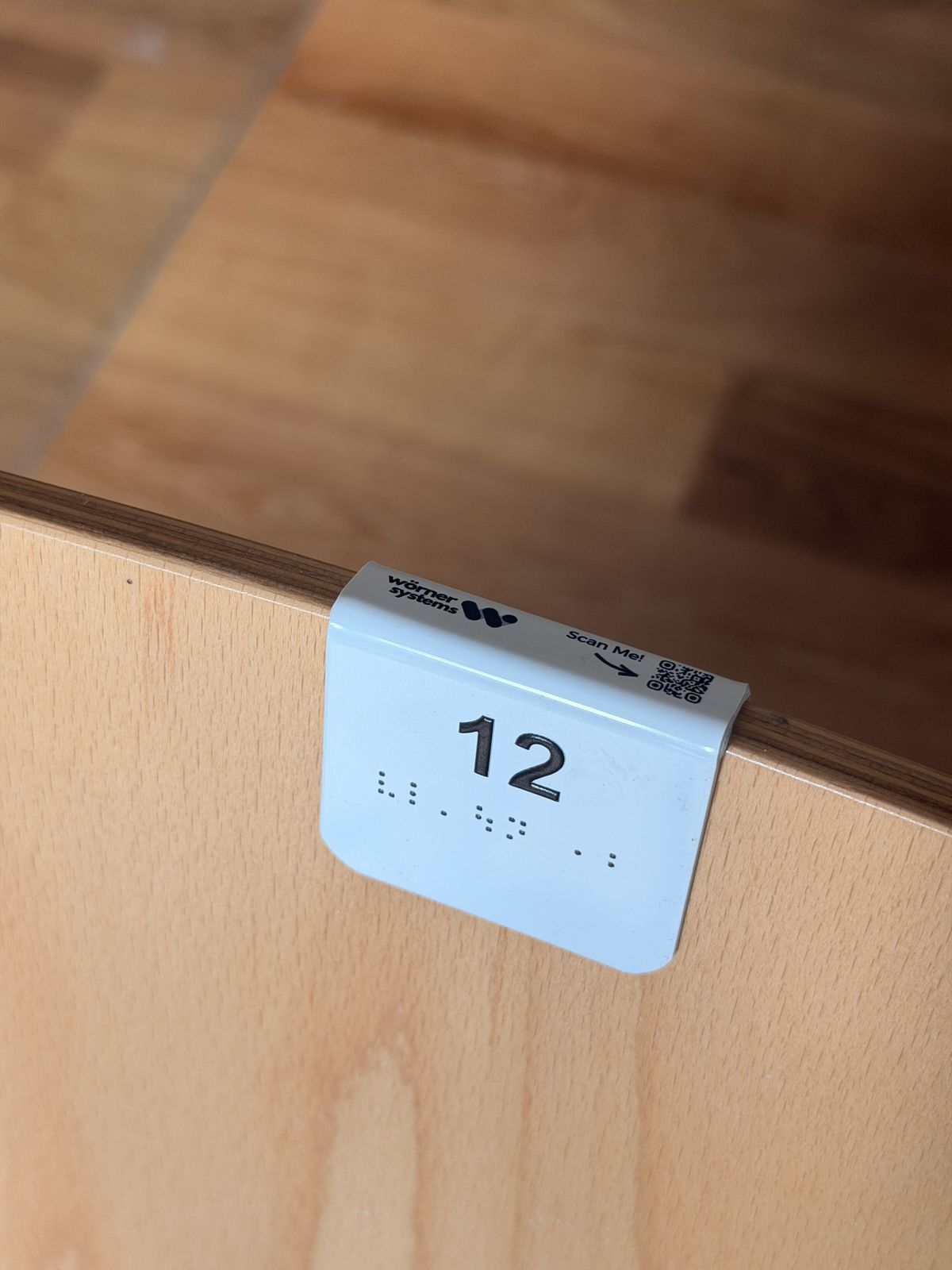 Seat number 12 with Braille on a wooden backrest