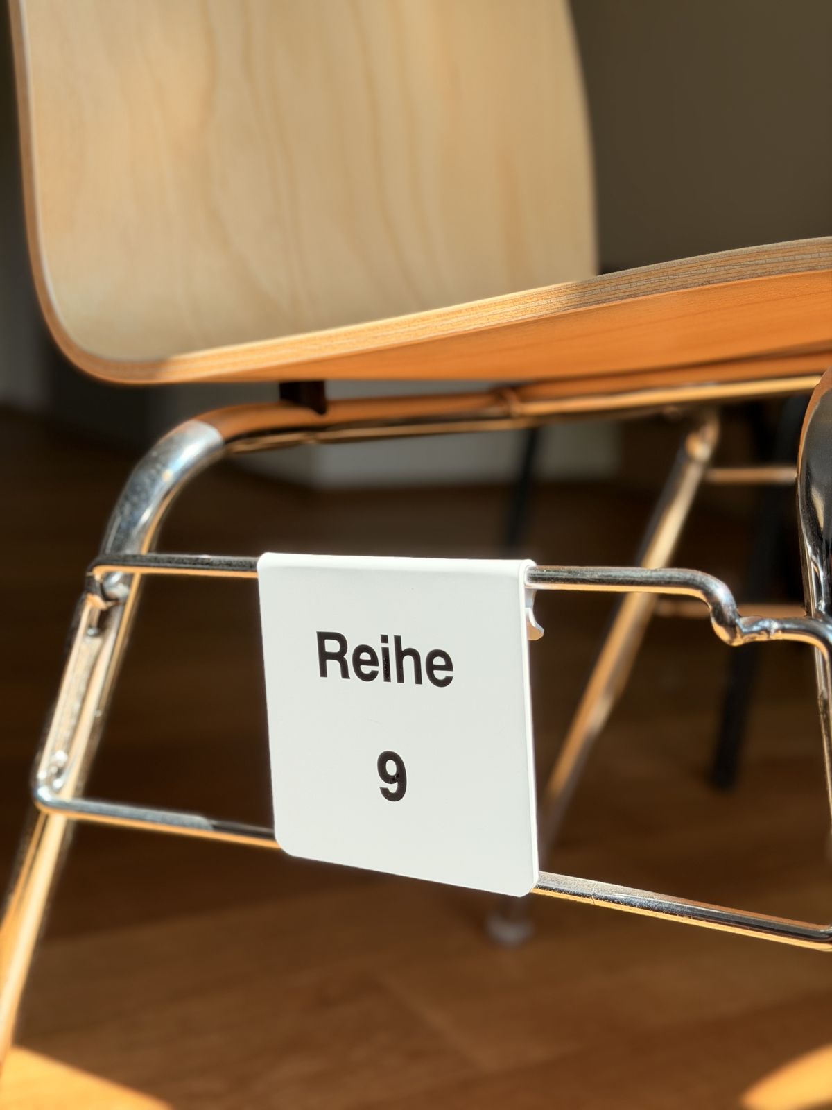 White row clip “Reihe 9” on a chrome chair tube