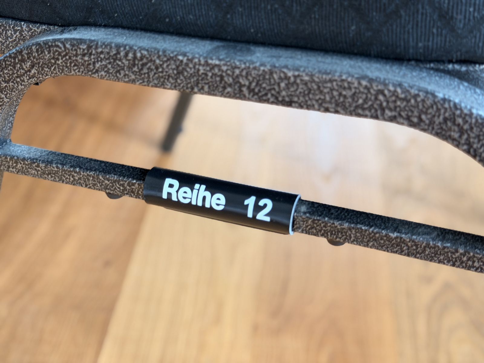Black tube sleeve “Reihe 12” on a chair frame