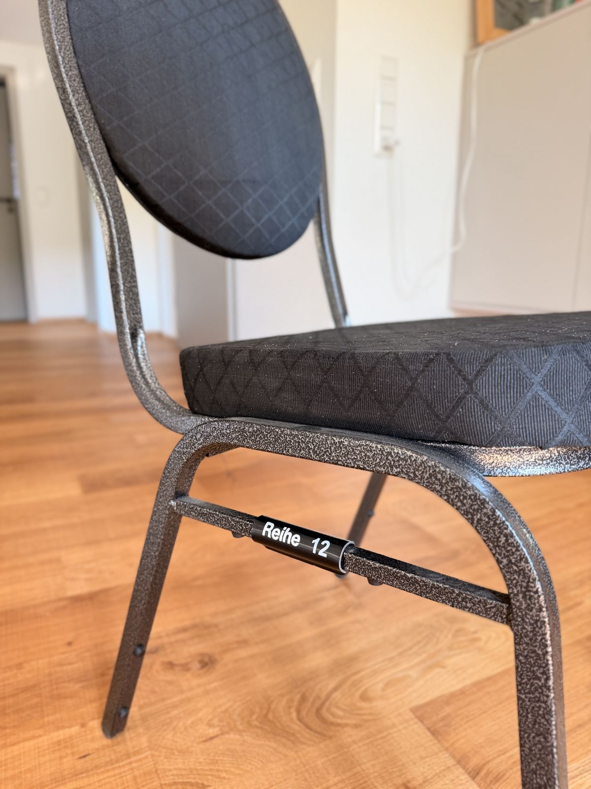 Chair with a black tube sleeve “Reihe 12” on the frame